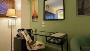 A room with a desk, chair, lamp, and wall art including a clock and a map. - Pols Studio - Project Kalamata Mediterranean Suites (Kalamata)