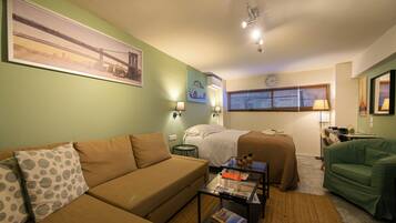 A room with a bed, a sofa, a coffee table, and a chair.