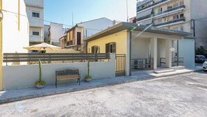 A residential building with a gated entrance, a bench, and potted plants. - Ilianas Home - Kalamata Mediterraean Suites & Villas (Kalamata)