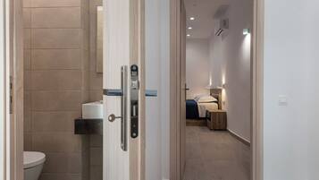Ein modernes Badezimmer mit Toilette, Handtuchspender und Duschbereich.