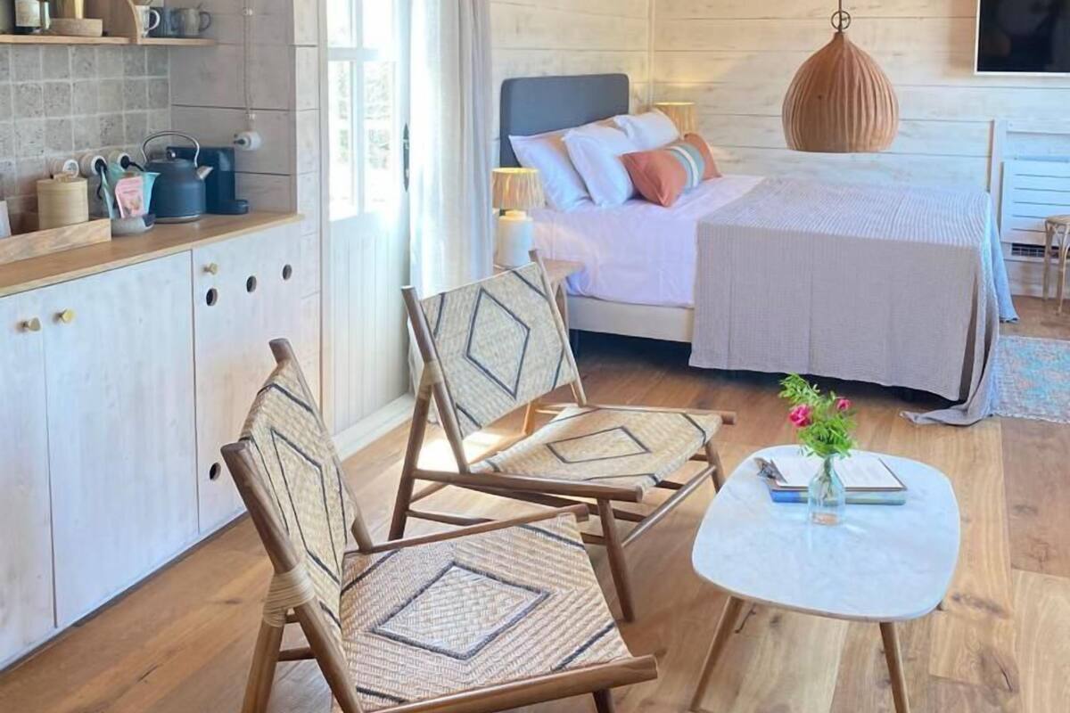 A cozy cabin-style room with a bed, a dining area, and a kitchen.