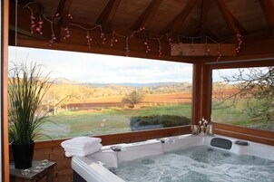 Un jacuzzi con vistas a un campo de césped y montañas.