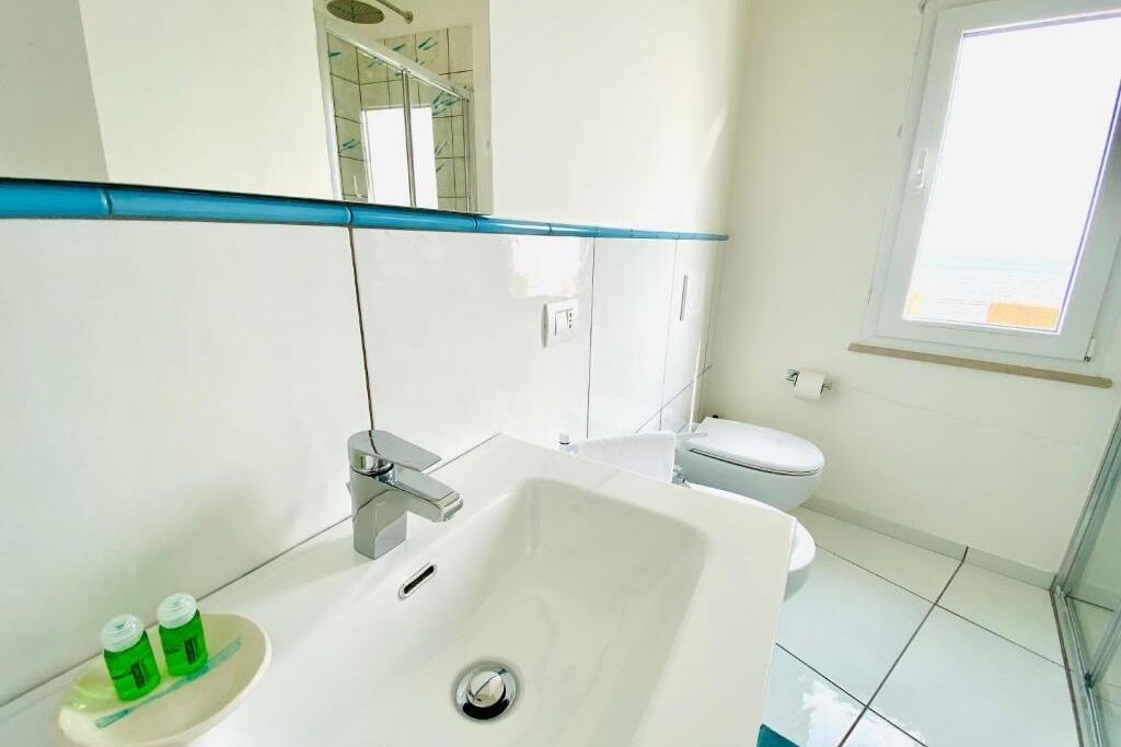 Une salle de bain moderne avec un lavabo blanc, des toilettes et une douche.