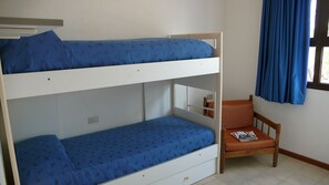 A bunk bed with a lower bunk and a chair with a magazine. - Bright house perfect for 6 near the beach (Bibione)