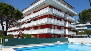 A multi-story building with a swimming pool. - Two-room apartment near the sea (Porto Santa Margherita)