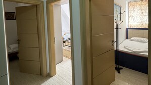 A hotel room with a bed, a wardrobe, and a bathroom visible through an open door.