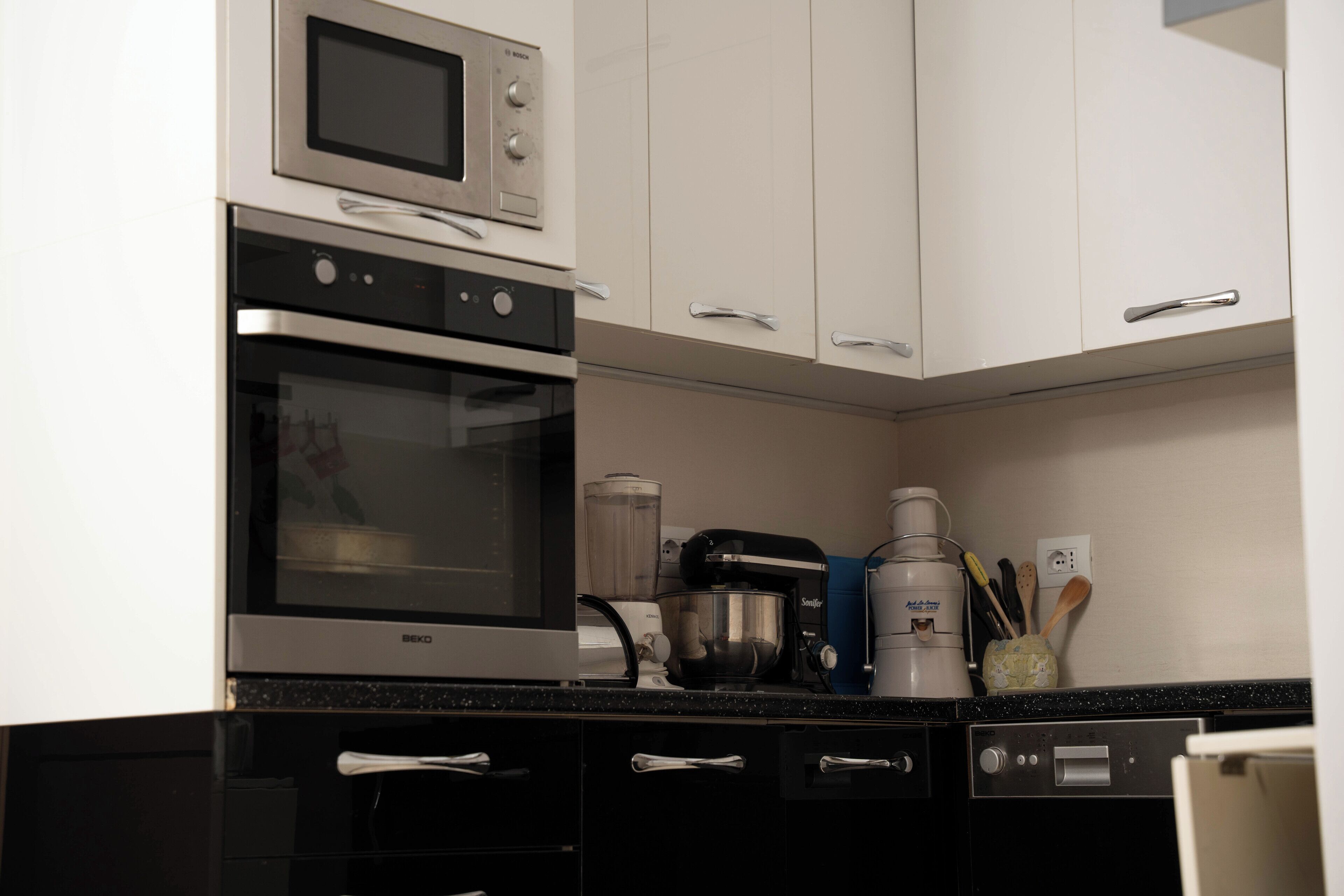 Eine Küche mit Backofen, Kaffeemaschine und verschiedenen Küchenutensilien.