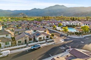 A residential area with houses, a swimming pool, and a mountain backdrop. - Desert Escape | Private Fire Pit & Pool Bliss (La Quinta)