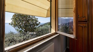 A room with a view of the sea, a window with a wooden frame, and a wooden door. - Seaview Apartment With Garden by Wonderful Italy (Recco)