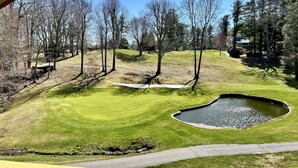 A golf course with a pond, trees, and a clear sky. - NEW Papa's Place on 1st hole Linville Land Harbor Pet Friendly  (Newland)