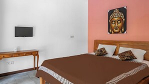 A bedroom with a bed, a desk, a television, and a Buddha painting. - Belvilla Nirvana Near Monkey ForestNearCampuhan Ridge Walk (Ubud)