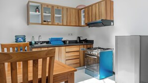 Una cocina moderna con armarios de madera, estufa a gas, horno empotrado y refrigerador.