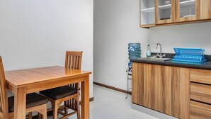 Cocina con armarios de madera, dispensador de agua, lavamanos y un teclado azul sobre la encimera.