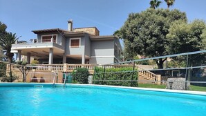 Une piscine avec une maison en arrière-plan.