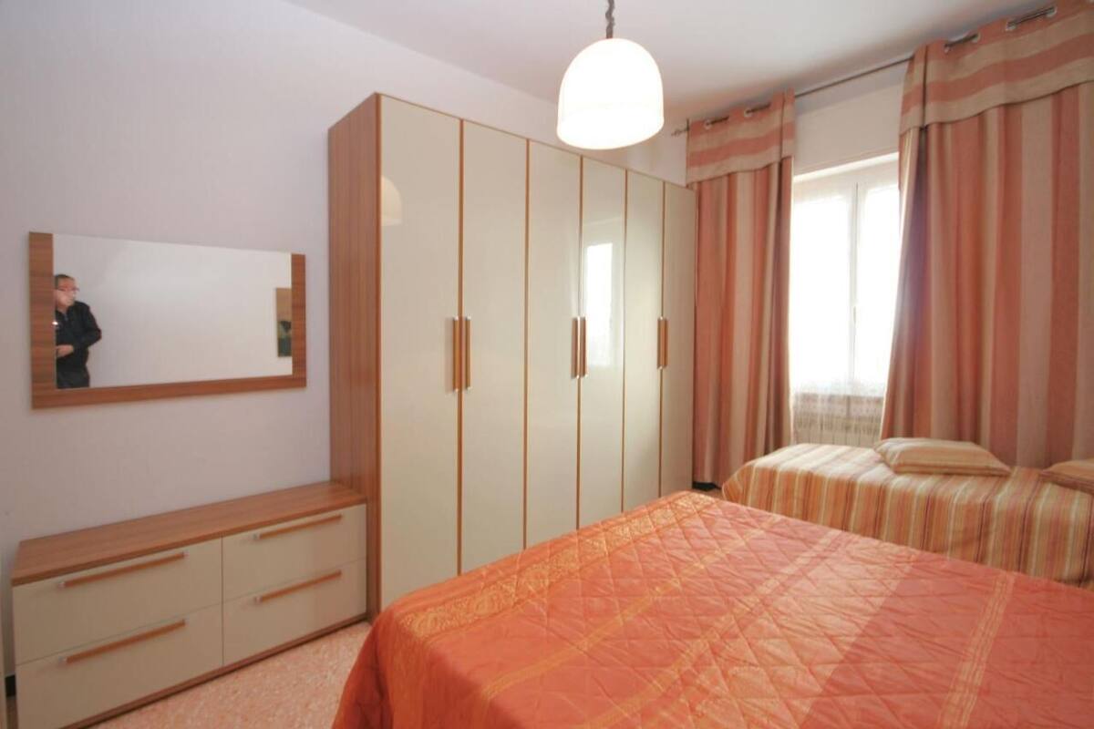 A bedroom with a bed, a wardrobe, a mirror, and curtains.