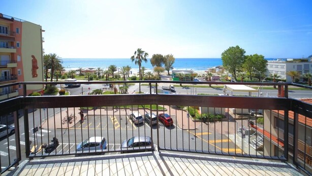 A balcony with a view of a parking lot, a building with a statue, and a clear blue sky. - Doria 6  (Andora)