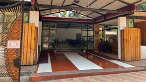A covered outdoor area with a wooden fence, a sign prohibiting mask and entry, and a tiled floor. - Raj Resort (Palghar)