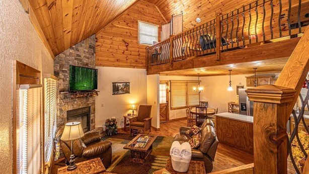A cozy living room with a fireplace, leather furniture, and a wooden ceiling. - Escape to the Dulce Mountain Cabin in Bryson City, NC (Bryson City)