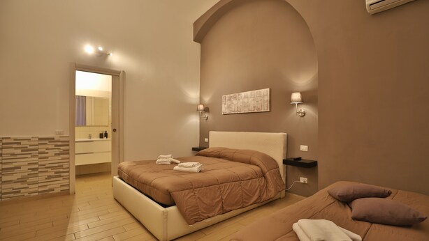 Una camera da letto con un letto, un comodino, una lampada e un'opera d'arte appesa al muro.
