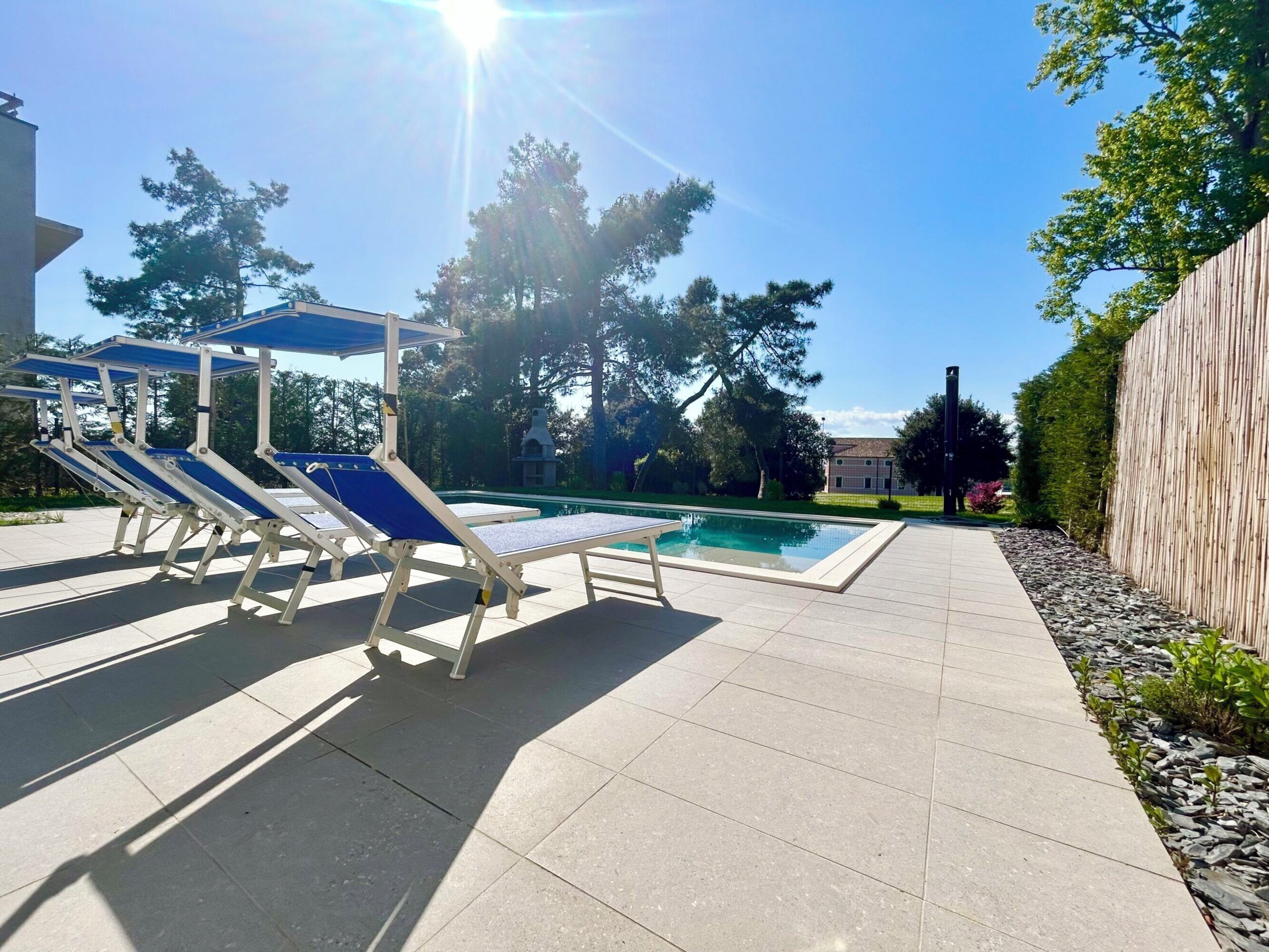 A swimming pool with lounge chairs and a pergola.