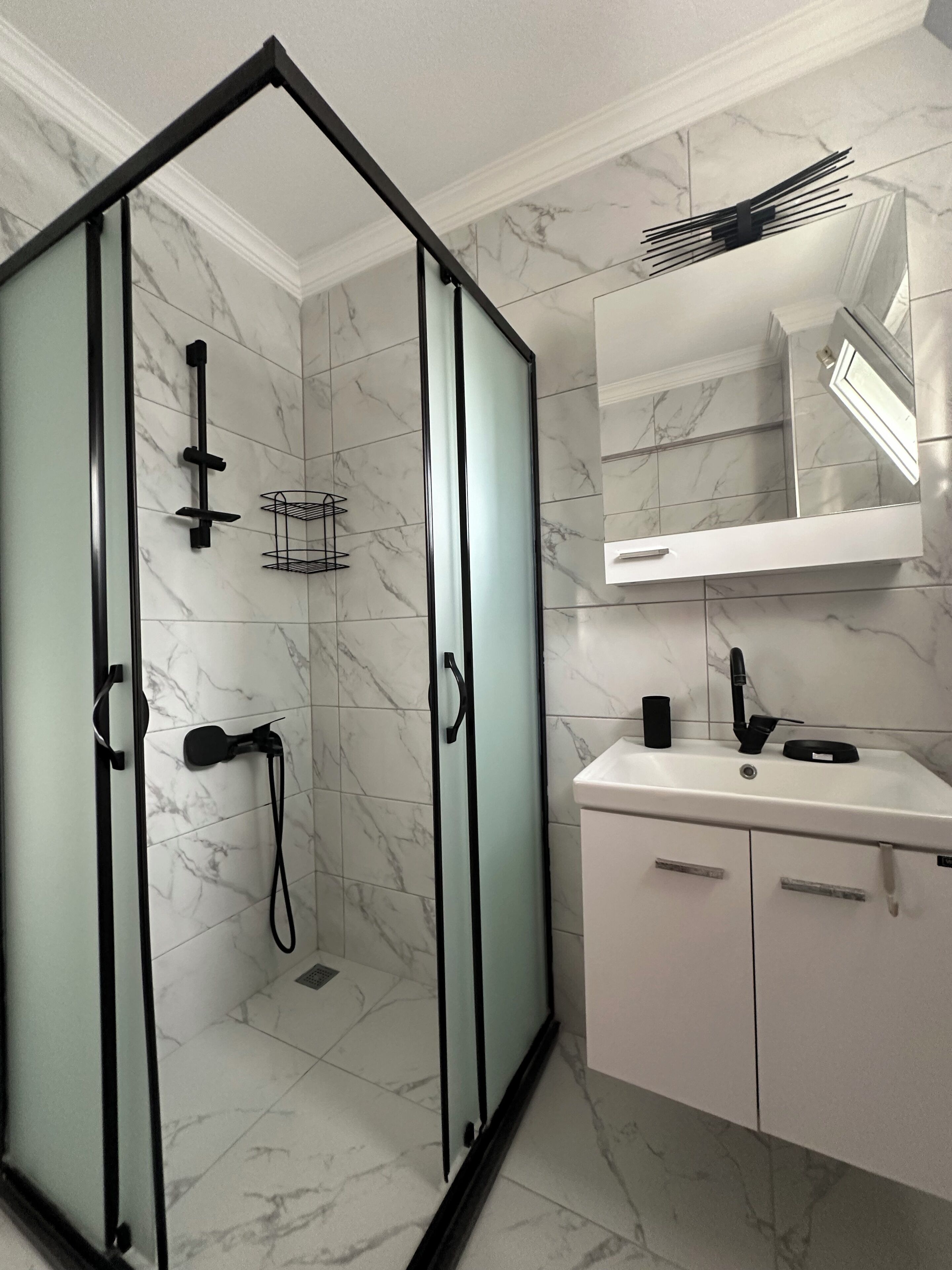 Eenvoudig appartement | Badkamer | Een douche, handdoeken, toiletpapier