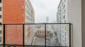 A balcony with a view of a cityscape, featuring buildings of various heights and architectural styles. - ShortStayPoland Skierniewicka B156 (Warsaw)