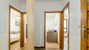 A hallway with wooden doors leading to a bedroom and a bathroom. - ShortStayPoland Skierniewicka B156 (Warsaw)