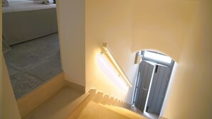 A staircase with a handrail and a light fixture. - Palazzo Lorizzo - Arcuève (Ostuni)