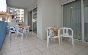 Enjoy a peaceful retreat on the balcony with a table, chairs, and a wicker basket.