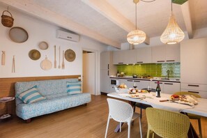 A modern kitchen with white cabinets, a green backsplash, and hanging light fixtures. - Eco friendly holiday for 7 guests Beahost Rentals (Bibione)