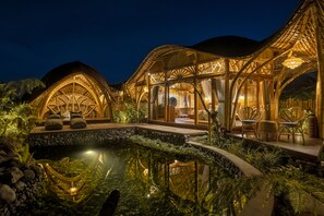 Un resort lujoso con una piscina grande, mobiliario exterior y un diseño arquitectónico bien iluminado.
