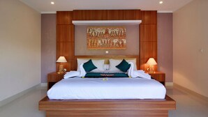 A modern hotel room with a large bed, wooden headboard, two bedside tables with lamps, and a decorative wall piece above the bed. - Belvilla Wanderlust Central UbudNearTiti Batu Ubud Club (Ubud)
