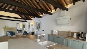 Una cocina moderna con una isla grande, vigas de madera en el techo y armarios azul claro.