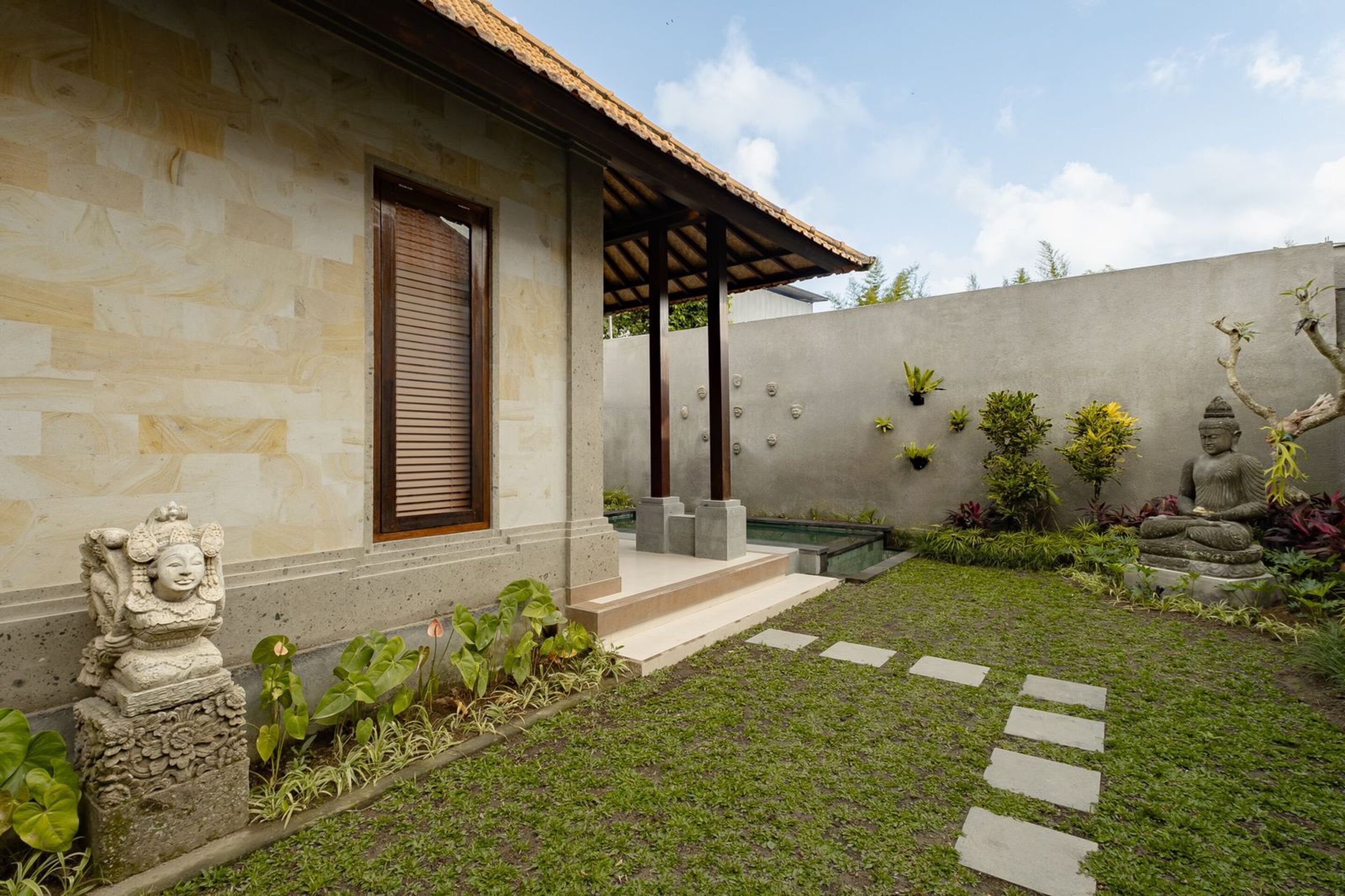 A modern house with a stone facade, a wooden door, and a small porch.
