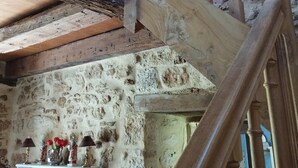 Eine Holztreppe vor einer Steinsäule.