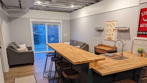 Una cocina moderna con una isla de madera, taburetes de bar y un amplio ventanal con vistas a un paisaje nevado.