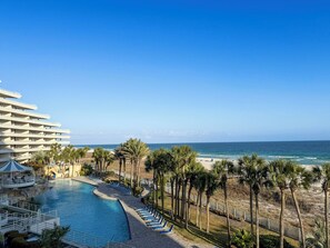 Um resort com piscina, praia e vista para o oceano.