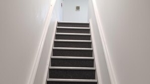 Eine Treppe mit weißen Wänden und einer Lampe oben.