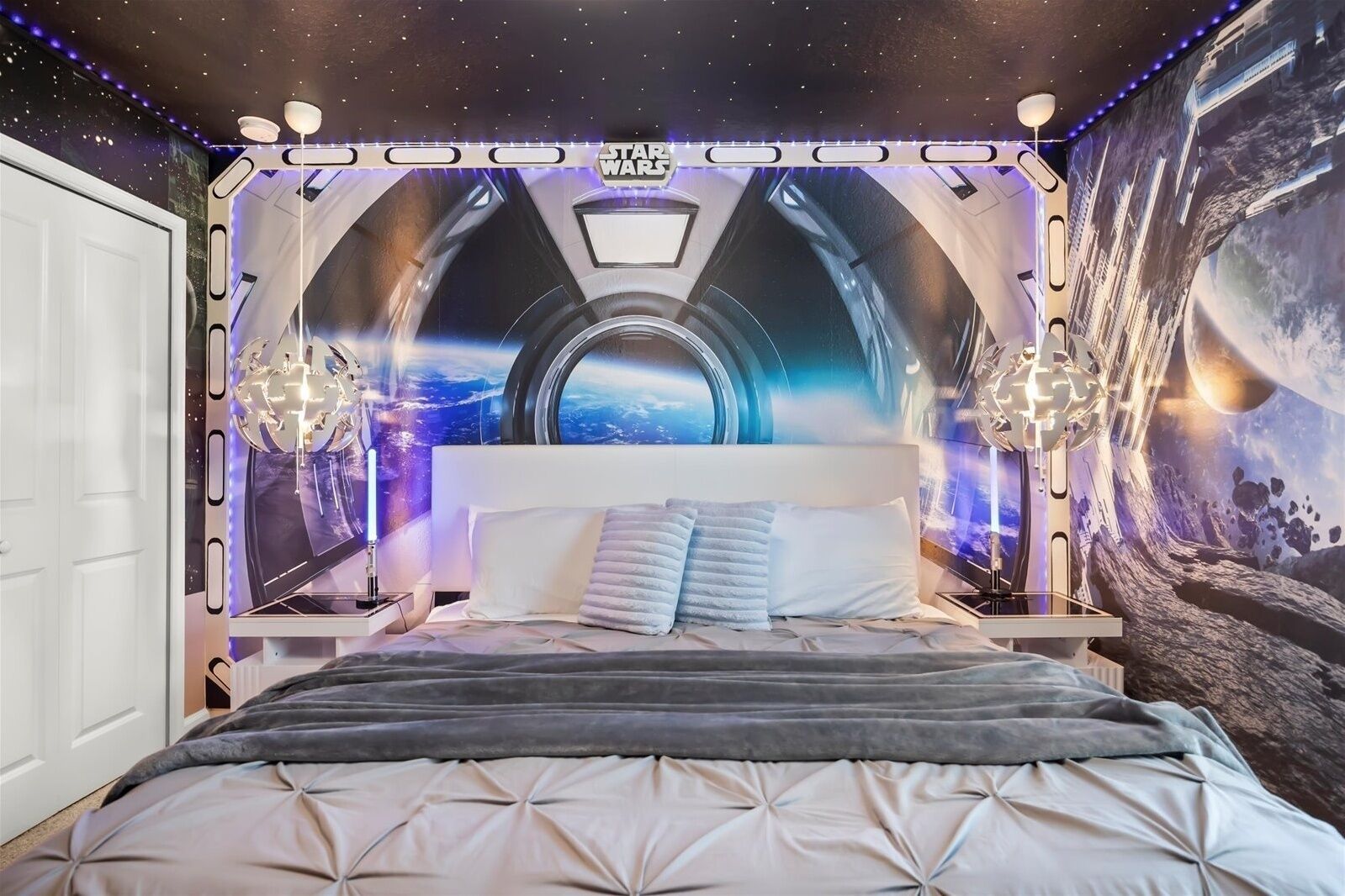 Une chambre à coucher décorée sur le thème de Star Wars, avec une grande fresque murale et des éclairages à LED.