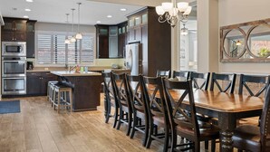 A modern kitchen with dark wood cabinets, stainless steel appliances, and a central island. - Paradise Private Pool Retreat #17 6 Bedroom Home (Ivins)