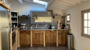 A kitchen with wooden cabinets, a large mirror, and a skylight. - Maison de Village Avec vue Exceptionnelle, Presqu'île de Saint Tropez (Gassin)