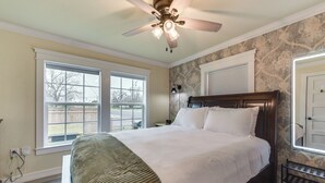 A bedroom with a large bed, a ceiling fan, and two windows. - 2 Mi to Dtwn: Chic Waco Studio w/ Fire Pit! (Waco)