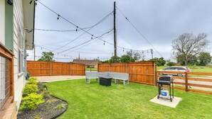 A backyard with a wooden fence, a barbecue grill, and a picnic table. - 2 Mi to Dtwn: Chic Waco Studio w/ Fire Pit! (Waco)
