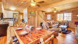 A wooden cabin interior with a dining area, kitchen, and living room. - Cropwell Cabin w/ Fire Pit, Near Logan Martin Lake (Cropwell)