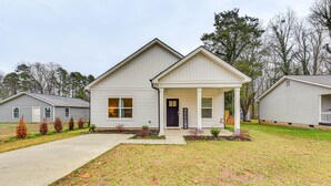 A single-story house with a front porch, a mailbox, and a small front yard with a lawn and a few shrubs.