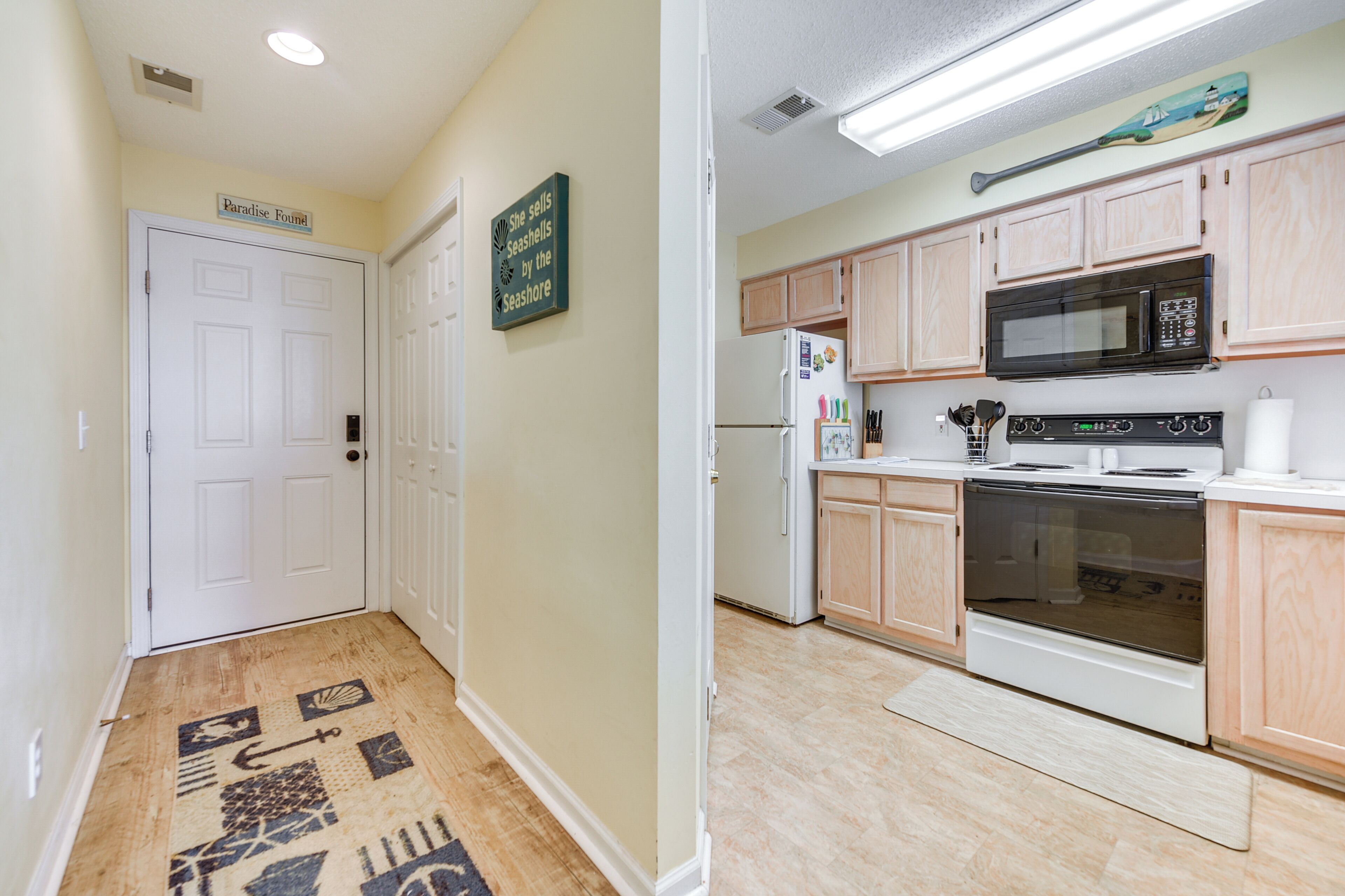 A kitchen with wooden cabinets, a microwave, a stove, and a refrigerator.