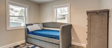 A bedroom with a bed, a ceiling fan, a window, and a wardrobe.