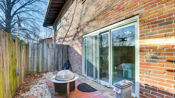 Un jardin avec un barbecue, une clôture en bois et une maison en briques.