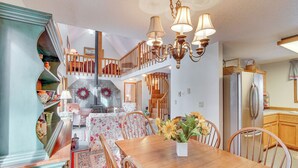 A dining area with a wooden table, chairs, and a vase of sunflowers. There is a staircase leading to an upper level. - Washington Mountain Cabin: 1 Mi to Lake Cle Elum (Cle Elum)