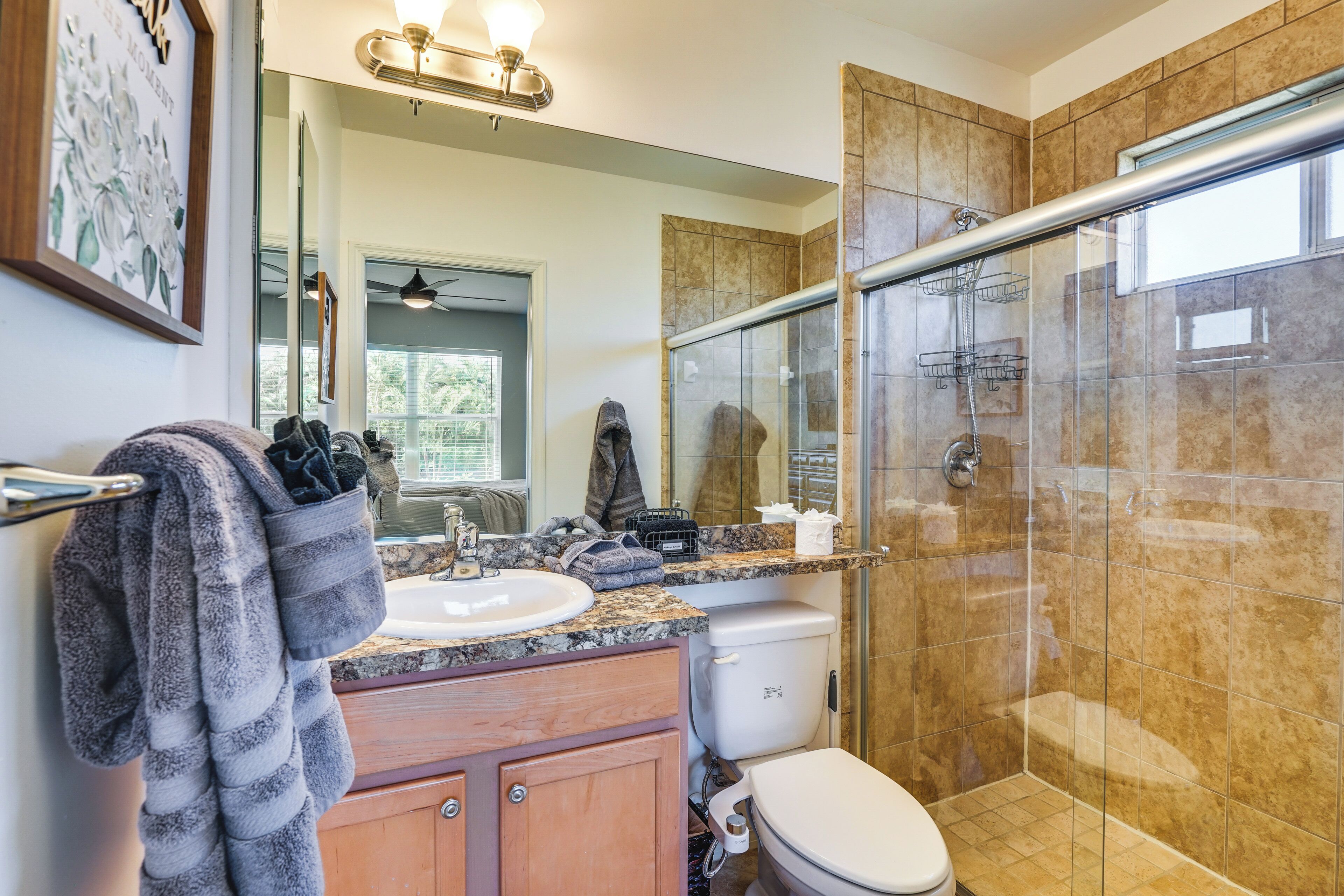 A bathroom with a sink, toilet, and glass shower enclosure.